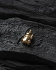 Gold beetle pendant on a dark stone surface