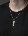 Gold necklace with a pendant on a black background