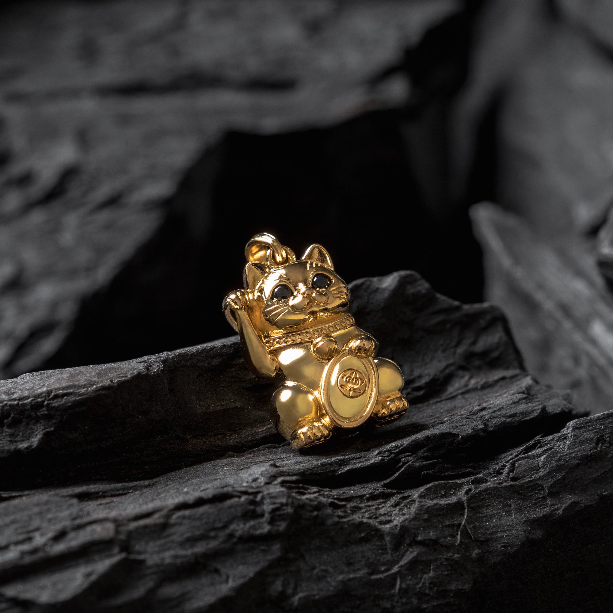 Gold cat-shaped figurine on dark stone surface