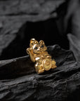 Gold cat-shaped figurine on dark stone surface