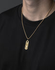Gold necklace with a pendant on a black background