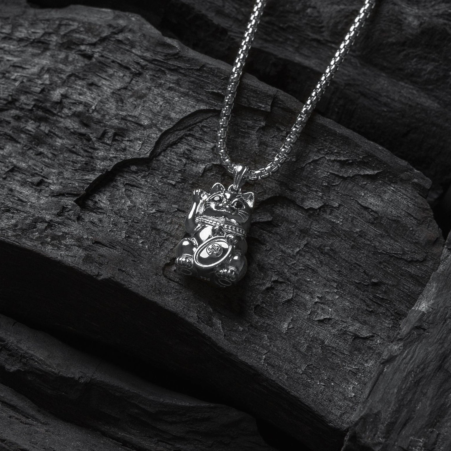 Silver necklace with a pendant on a dark stone surface