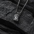 Silver necklace with a pendant on a dark stone surface