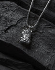 Silver necklace with a pendant on a dark stone surface